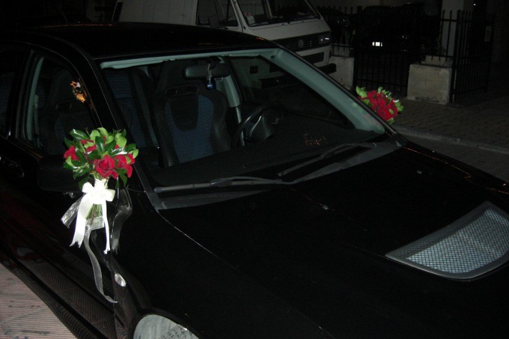 Στολισμός αυτοκίνητου γάμου με κόκκινα μπουκέτα στους καθρέπτες