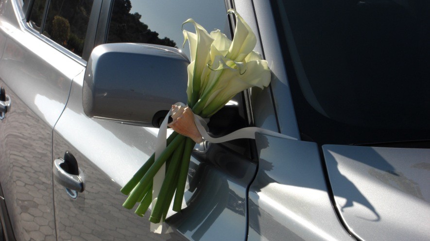 Στολισμός αμαξιού για γάμο με μπουκέτα στους καθρέπτες από λευκές κάλλες και κοχύλι