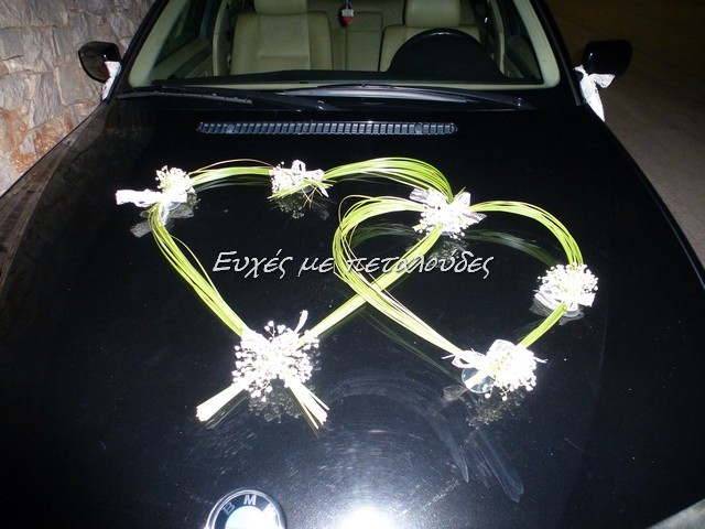 Στολισμός νυφικού αυτοκινήτου με καρδιές από grass και δεμένα μικρά μπουκετάκια λουλουδιών